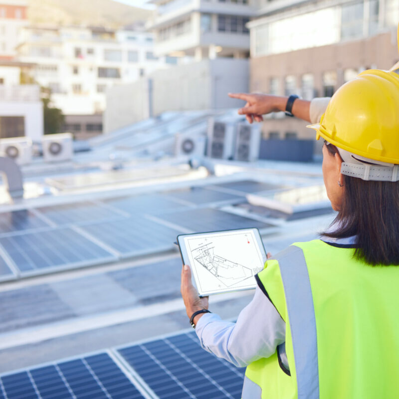 Técnicos de Helexia analizando una instalación de autoconsumo solar en una empresa durante la Era de la Electricidad.