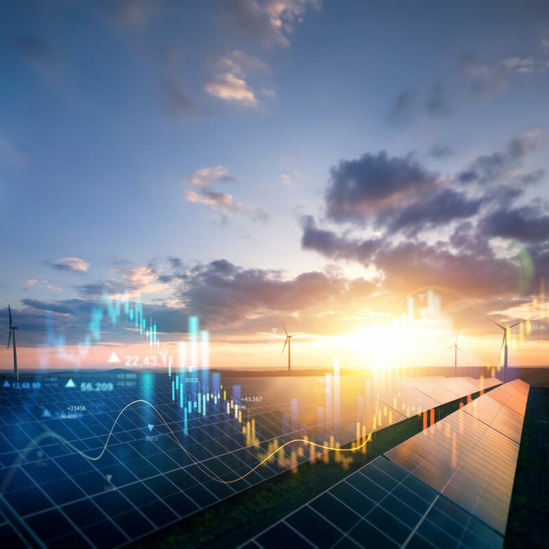 Planta solar fotovoltaica con aerogeneradores al atardecer y gráficos digitales superpuestos que representan la gestión inteligente, el almacenamiento y la flexibilidad energética.
